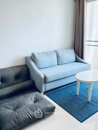 Modern living room with stylish blue sofa and cozy seating area.