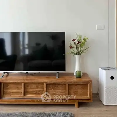 Modern living room with sleek TV stand, large flat-screen TV, and stylish decor for a cozy ambiance.