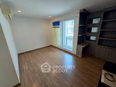 Spacious empty room with wooden flooring and built-in shelves, ideal for customization.