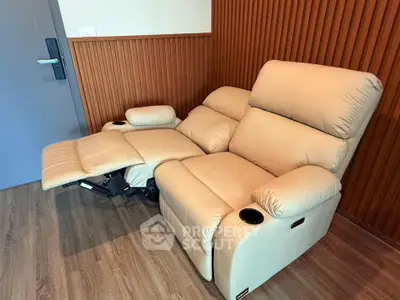 Luxurious beige recliner in modern living room with wood paneling and sleek flooring.