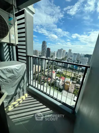 Stunning city view from a high-rise balcony with clear blue skies.