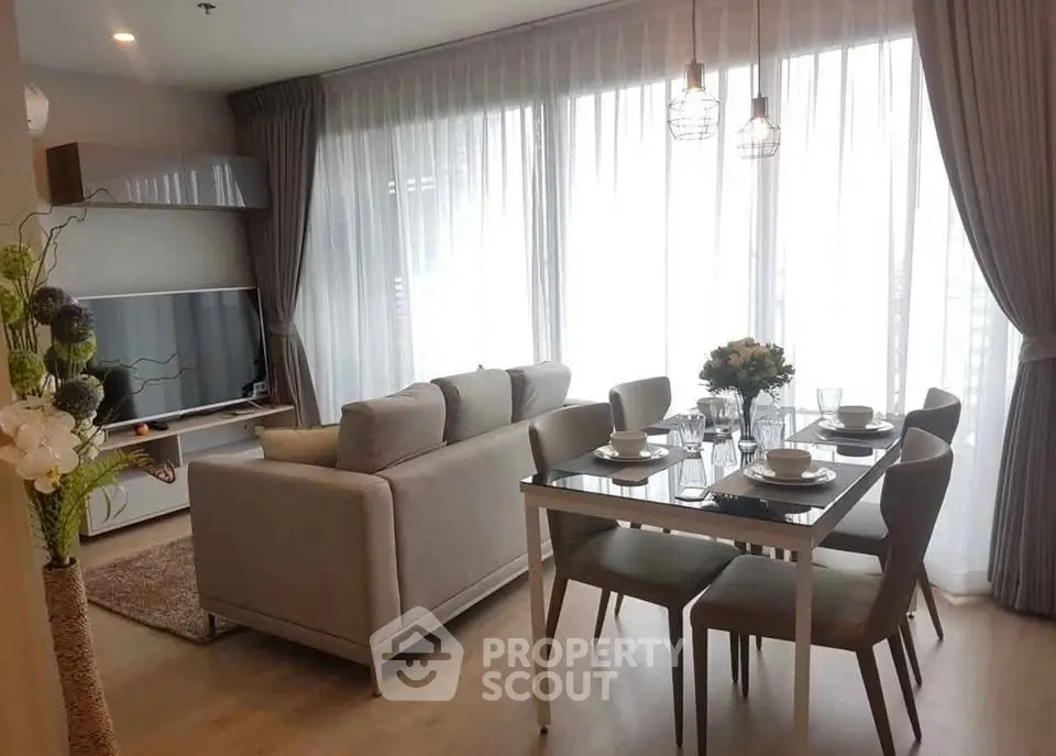 Modern living room with elegant dining area and large windows in a stylish apartment.