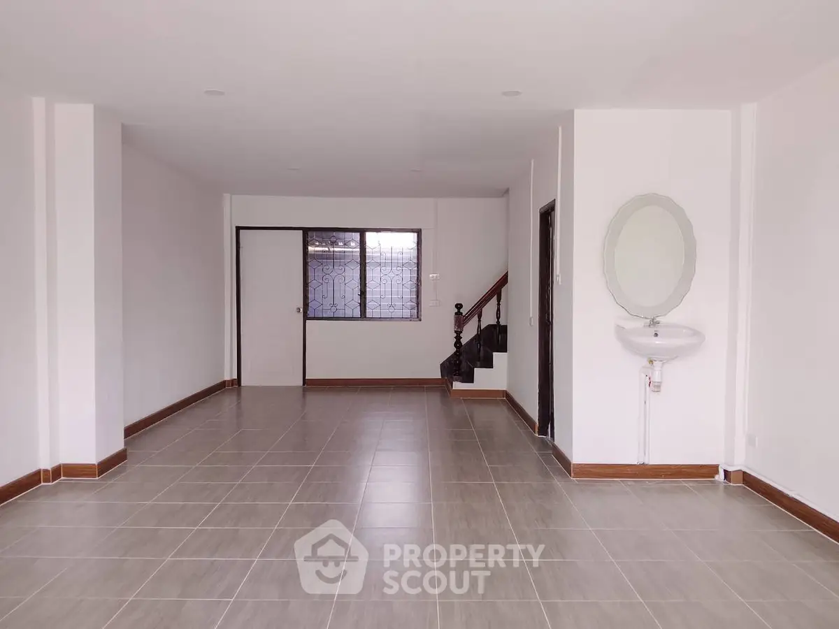 Spacious open-plan interior with tiled flooring and modern staircase, ideal for versatile living arrangements.