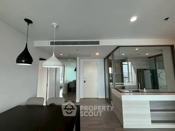 Modern open-plan kitchen and dining area with stylish lighting and sleek design.