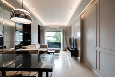 Modern living room with elegant decor and natural light, featuring a cozy sofa and sleek TV setup.