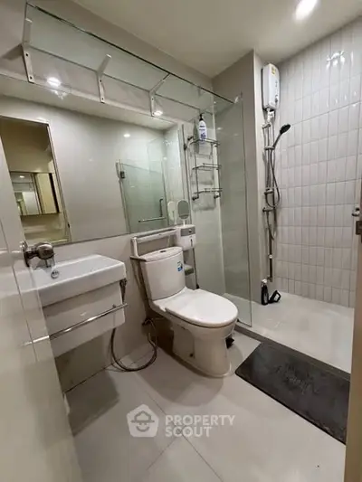 Modern bathroom with glass shower and sleek fixtures in a contemporary home.