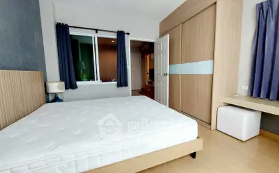 Modern bedroom with large window and built-in wardrobe in stylish apartment