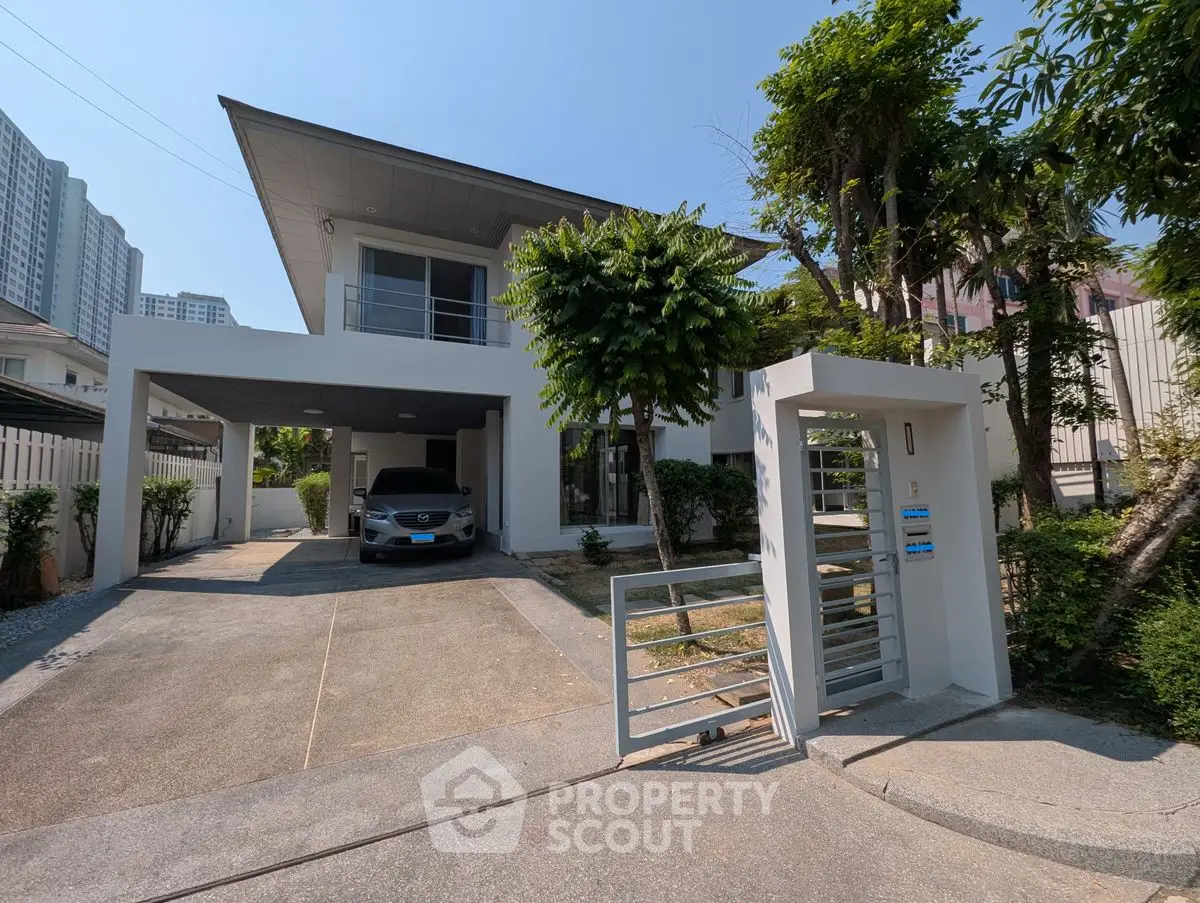 Modern two-story house with driveway and carport in a serene neighborhood.