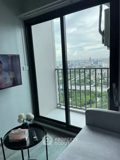 Modern living room with balcony offering stunning city view, perfect for urban living.