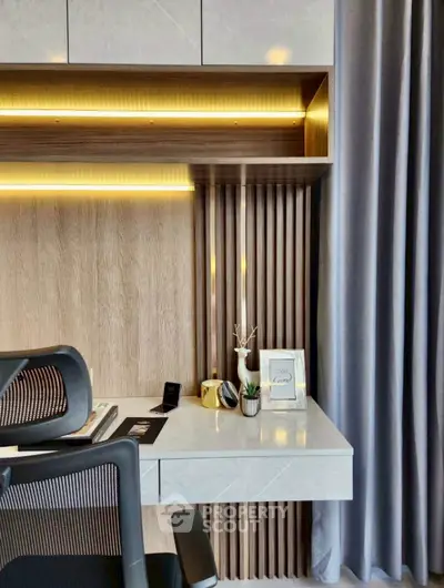 Modern study area with sleek desk, ergonomic chair, and elegant decor in a stylish home office setting.