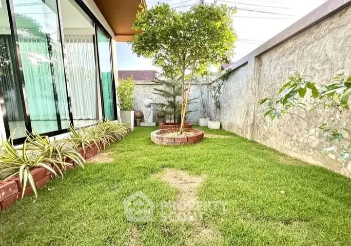 Charming garden with lush greenery and modern glass facade, perfect for relaxation and outdoor enjoyment.
