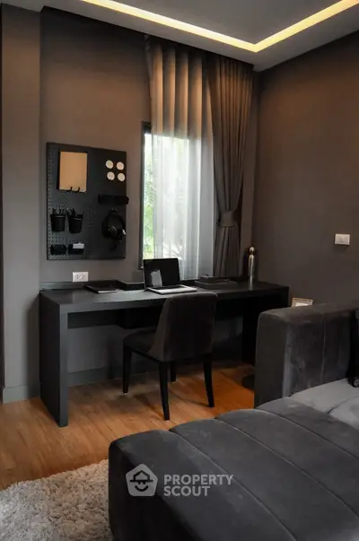 Modern study room with sleek desk and cozy seating area, perfect for productivity.