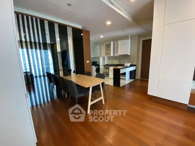 Spacious modern dining area with open kitchen and wooden flooring in luxury apartment