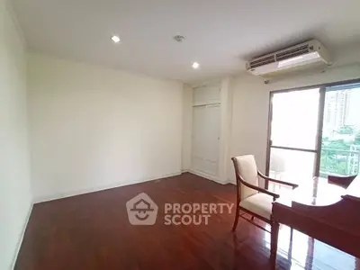 Spacious living room with hardwood floors and balcony view in modern apartment.