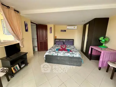 Cozy bedroom with modern decor, featuring a comfortable bed, wardrobe, and air conditioning.