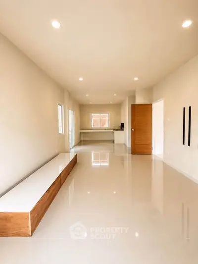 Spacious modern living room with sleek flooring and ample natural light, perfect for contemporary living.