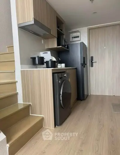 Modern compact kitchen with washing machine and sleek wooden cabinetry