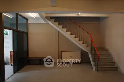 Spacious interior with modern staircase and glass partition, ideal for stylish urban living.