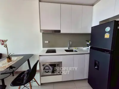 Modern compact kitchen with sleek cabinets and appliances in a stylish apartment.