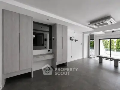 Spacious modern living room with large windows and sleek built-in storage.
