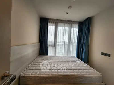 Cozy bedroom with large window and modern design, perfect for relaxation and comfort.