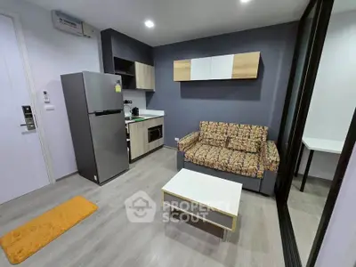 Modern living room with compact kitchen and stylish decor in a cozy apartment.