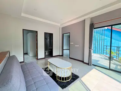 Modern living room with stylish furniture and access to a spacious balcony with scenic views.