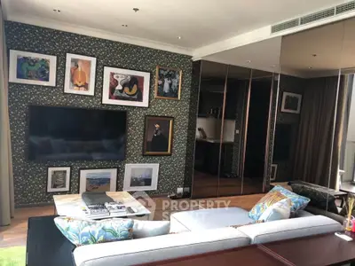 Stylish living room with modern decor and wall art, featuring a large TV and comfortable seating.