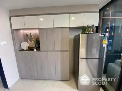 Modern kitchen with sleek cabinetry and stainless steel fridge in stylish apartment