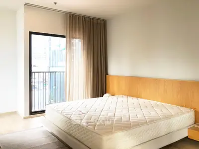 Spacious bedroom with large window and modern decor in urban apartment