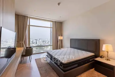 Luxurious bedroom with city view, featuring modern furnishings and large windows for natural light.