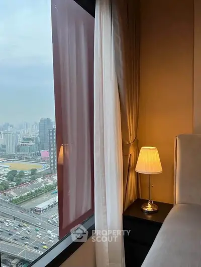 Luxurious bedroom with stunning city view and elegant bedside lamp