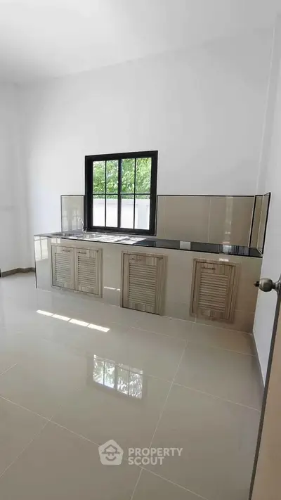 Modern kitchen with sleek cabinetry and large window for natural light