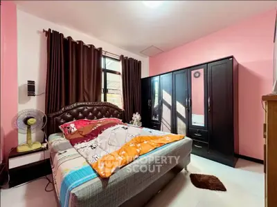Cozy bedroom with stylish furniture and ample natural light, perfect for relaxation and comfort.