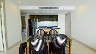 Modern dining area with sleek kitchen and stylish black chairs in open layout apartment.