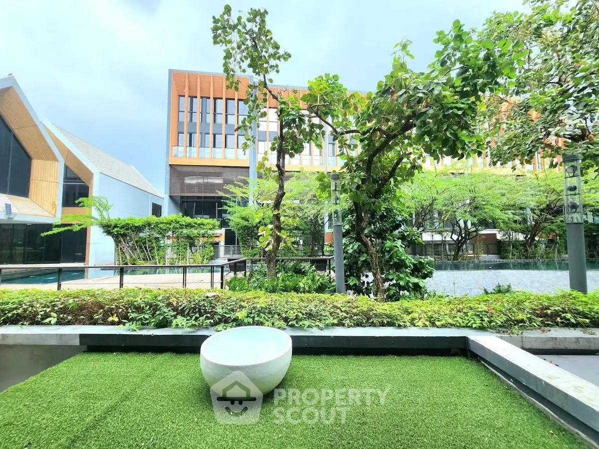 Modern building exterior with lush garden and unique outdoor seating