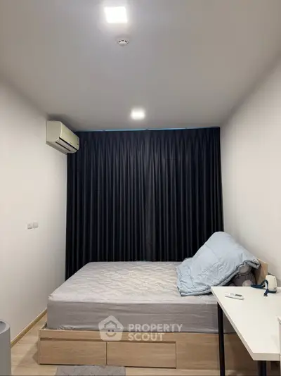 Cozy bedroom with modern decor and ample natural light, featuring a comfortable bed and sleek furnishings.