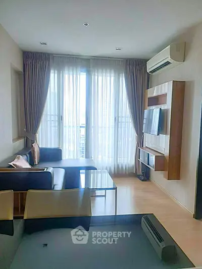 Modern living room with sleek furniture and large windows offering ample natural light.