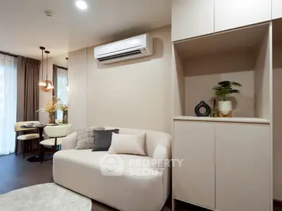 Modern living room with stylish decor and dining area, featuring a cozy sofa and elegant lighting.
