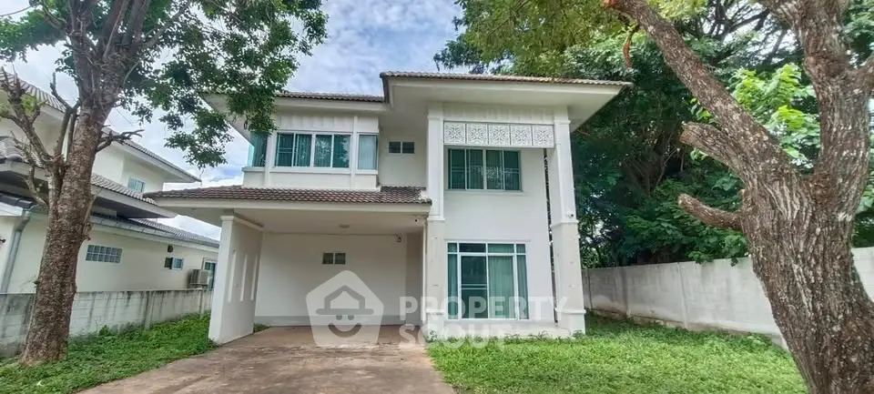 Charming two-story house with spacious driveway and lush greenery
