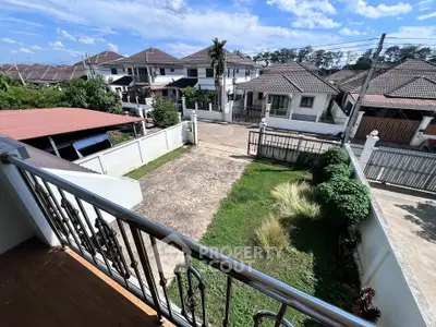 Charming suburban view from balcony with spacious driveway and lush greenery.