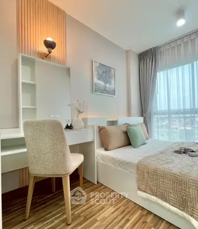 Modern bedroom with stylish decor and large window offering natural light and scenic views.