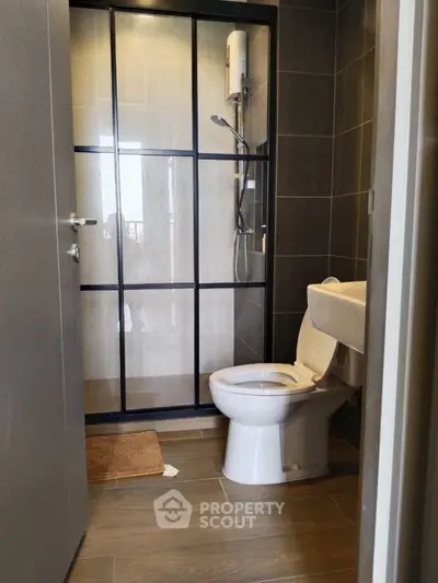 Modern bathroom with sleek shower and toilet in contemporary design.