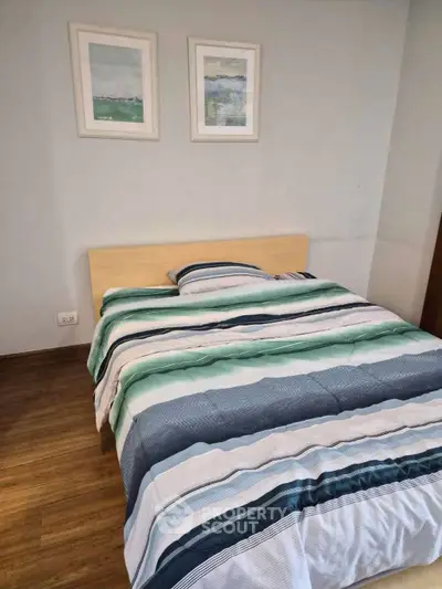 Cozy bedroom with modern decor and wooden flooring, perfect for relaxation.