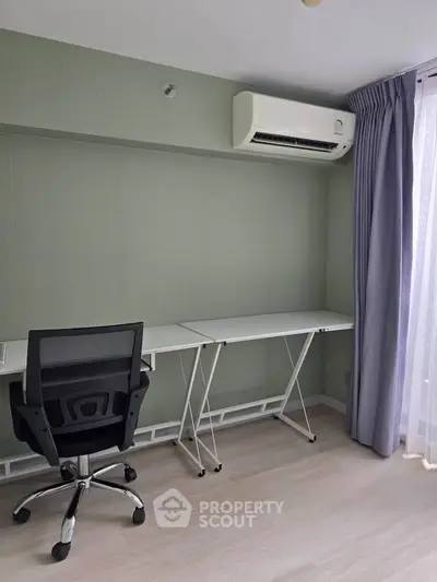 Modern study room with sleek desk, ergonomic chair, and air conditioning in a bright apartment.
