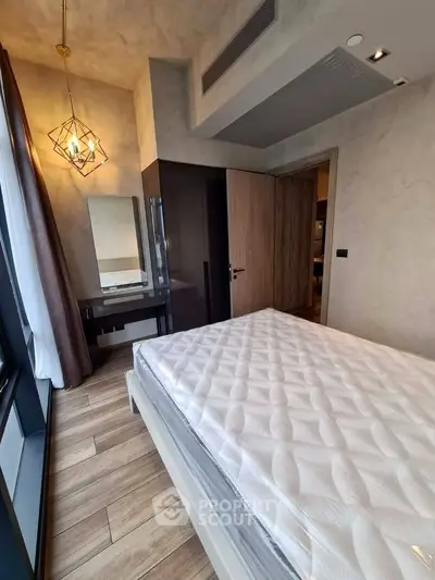 Modern bedroom with stylish decor and large window offering natural light.