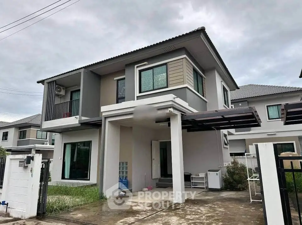 Modern two-story house with a sleek design and spacious driveway in a suburban neighborhood.