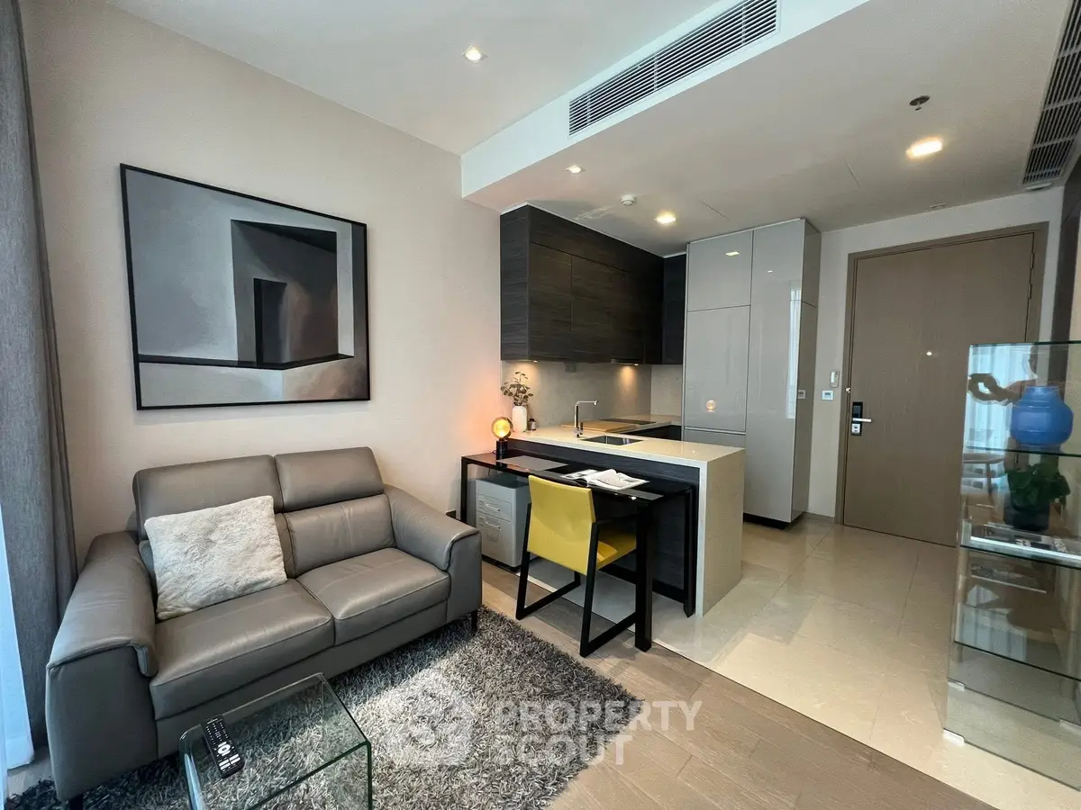 Modern living room with sleek kitchen, cozy sofa, and stylish decor in open layout apartment.