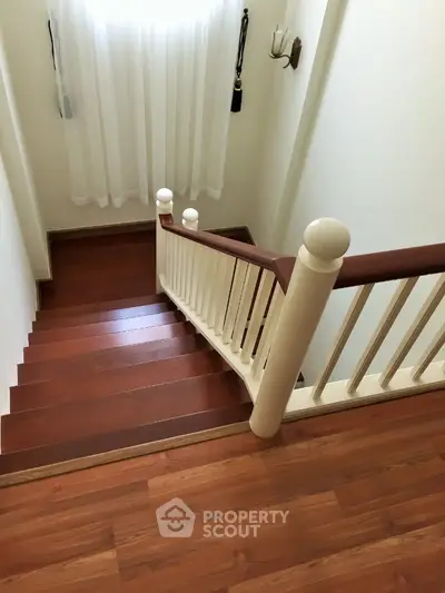 Elegant wooden staircase with natural light and classic railing design