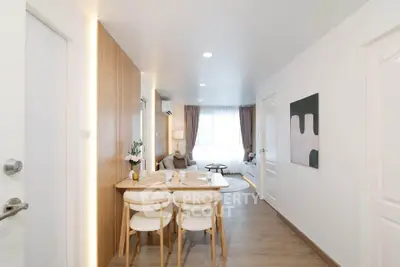 Modern dining area with wooden accents and cozy living room in open layout apartment.